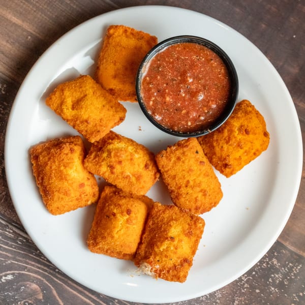 Alesi Pizza House's toasted ravioli, golden brown and crispy, served with a side of marinara sauce.