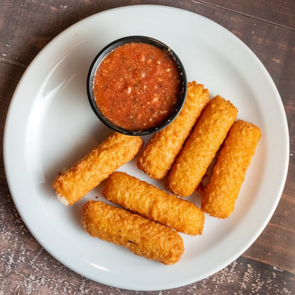 Golden-brown mozzarella sticks and a side of red marinara sauce on a white plate.