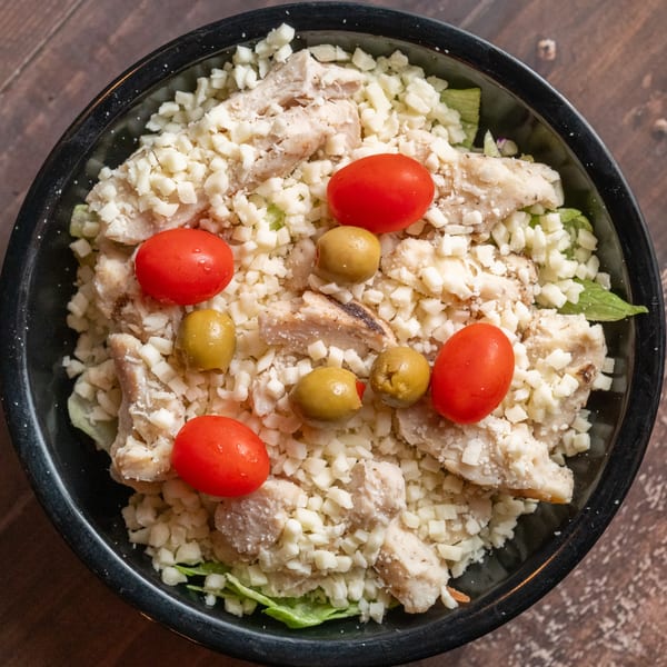 Alesi Pizza House's chicken salad with diced cheese, cherry tomatoes, and green olives.