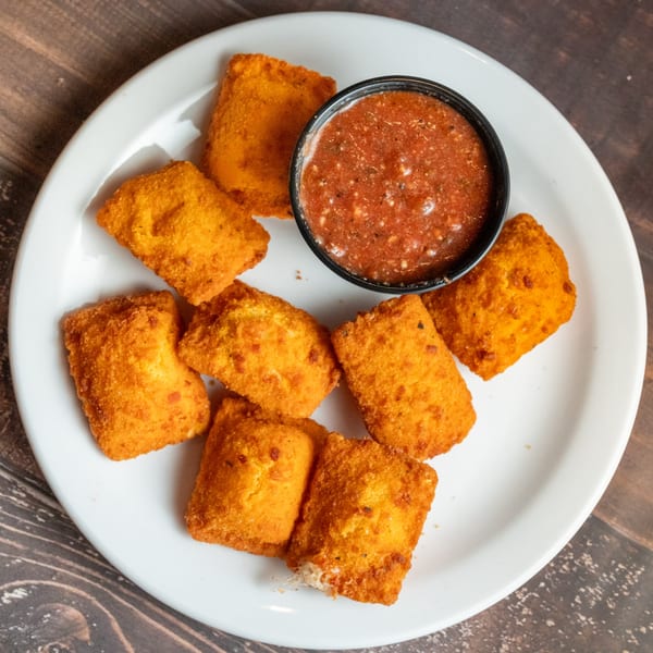 Alesi Pizza House's fried ravioli appetizer with a side of marinara sauce on a white plate.